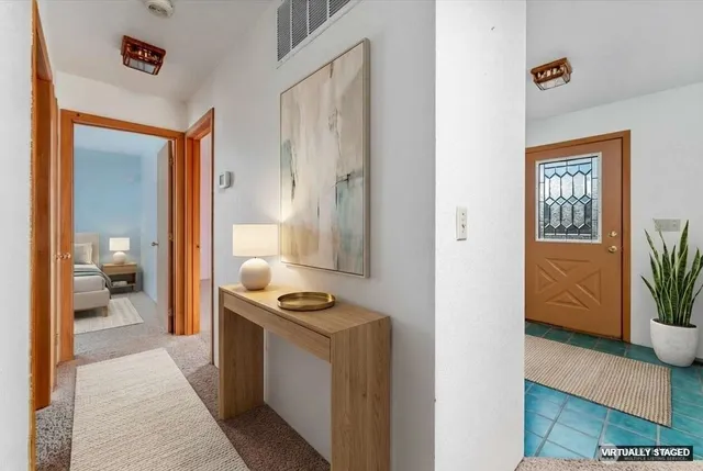 a hallway with a couch and a view of bathroom