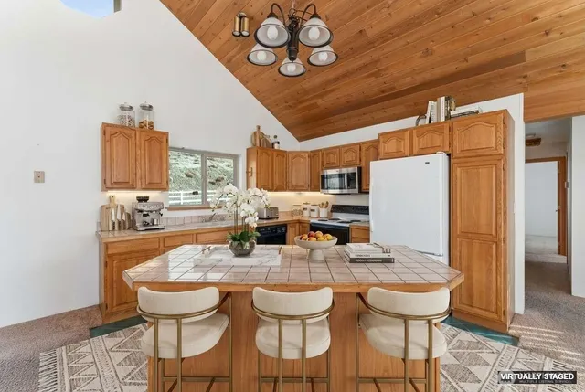 a dining room with stainless steel appliances kitchen island granite countertop a dining table and chairs