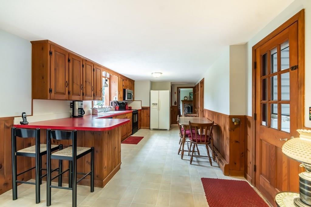 19 Willow Road Boxford, MA 01921 - Photo 13 of 32 a kitchen with stainless steel appliances granite countertop a table chairs and a refrigerator