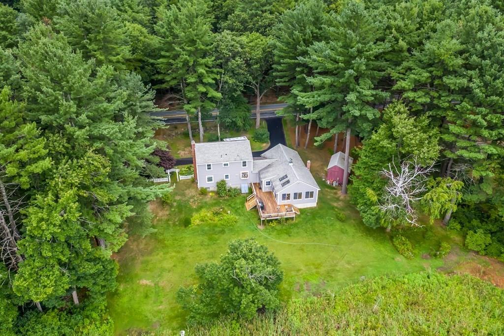 19 Willow Road Boxford, MA 01921 - Photo 4 of 32 a backyard of a house with table and chairs a barbeque and a lots of plants