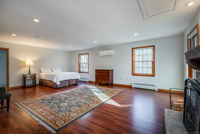 a spacious bedroom with a bed a mirror and a window