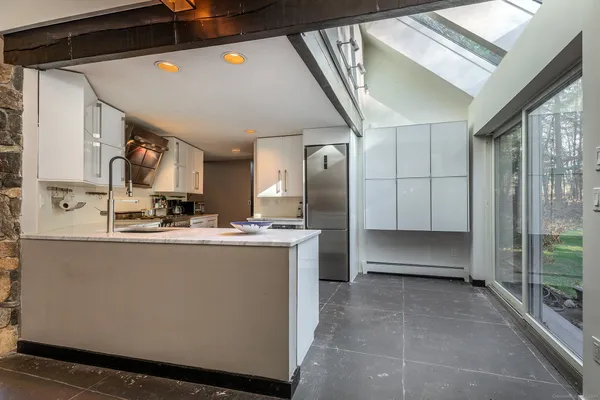 a view of kitchen with stainless steel appliances granite countertop a refrigerator and a sink