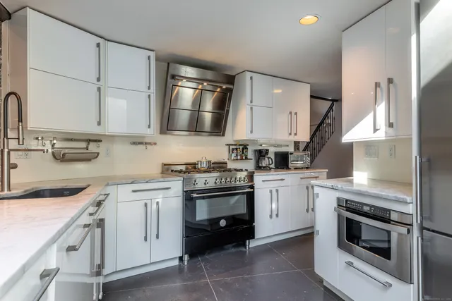 a kitchen with white cabinets and appliances
