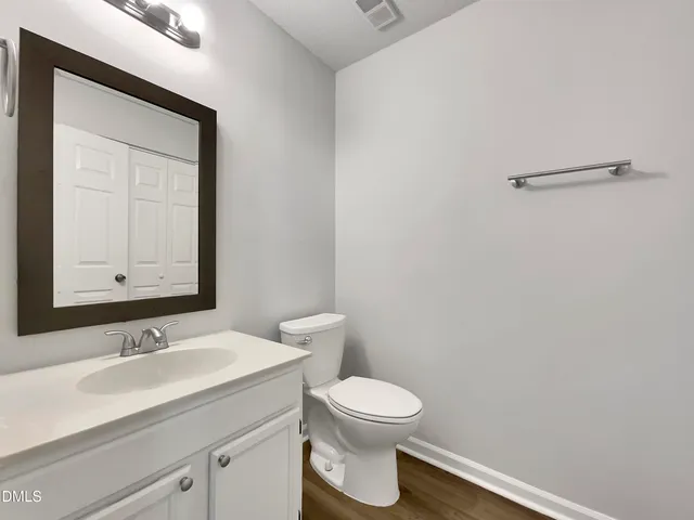 a bathroom with a toilet a sink and mirror