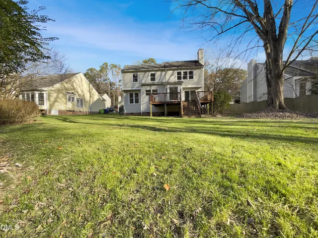 a view of a house with a big yard and large trees