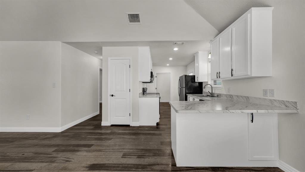 1830 Hitching Post Road Granbury, TX 76049 - Photo 14 of 34 a kitchen with stainless steel appliances granite countertop a refrigerator sink and white cabinets