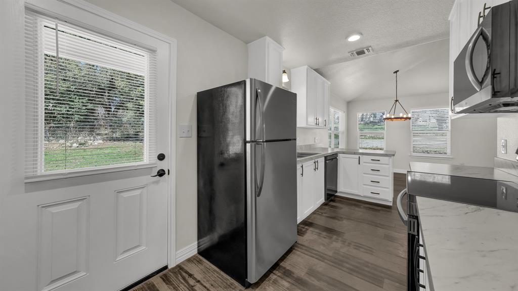 1830 Hitching Post Road Granbury, TX 76049 - Photo 17 of 34 a kitchen with stainless steel appliances a refrigerator and a stove