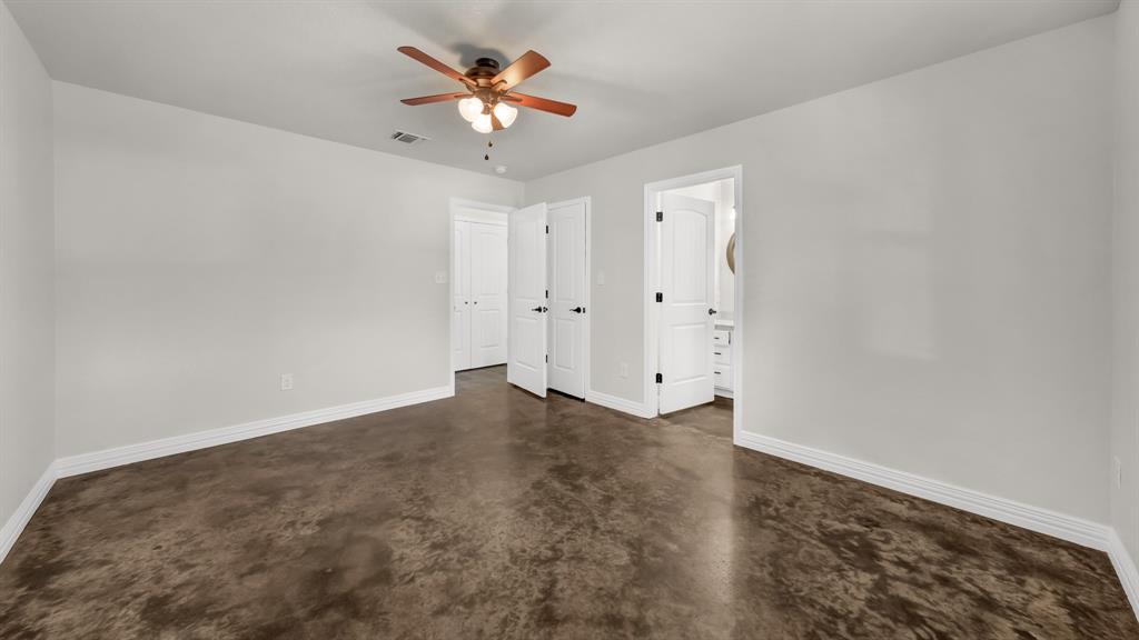 1830 Hitching Post Road Granbury, TX 76049 - Photo 22 of 34 an empty room with a chandelier fan and wooden floor