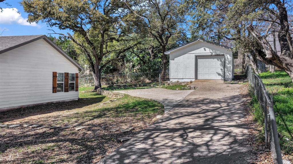 1830 Hitching Post Road Granbury, TX 76049 - Photo 31 of 34 a view of a house with a yard tree and wooden fence