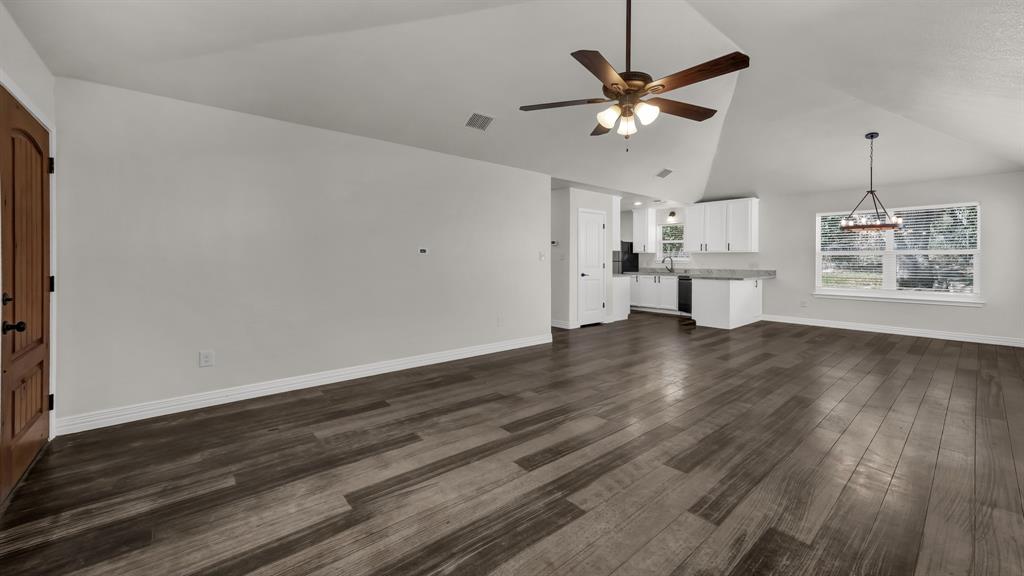 1830 Hitching Post Road Granbury, TX 76049 - Photo 5 of 34 a view of an empty room with a window and wooden floor