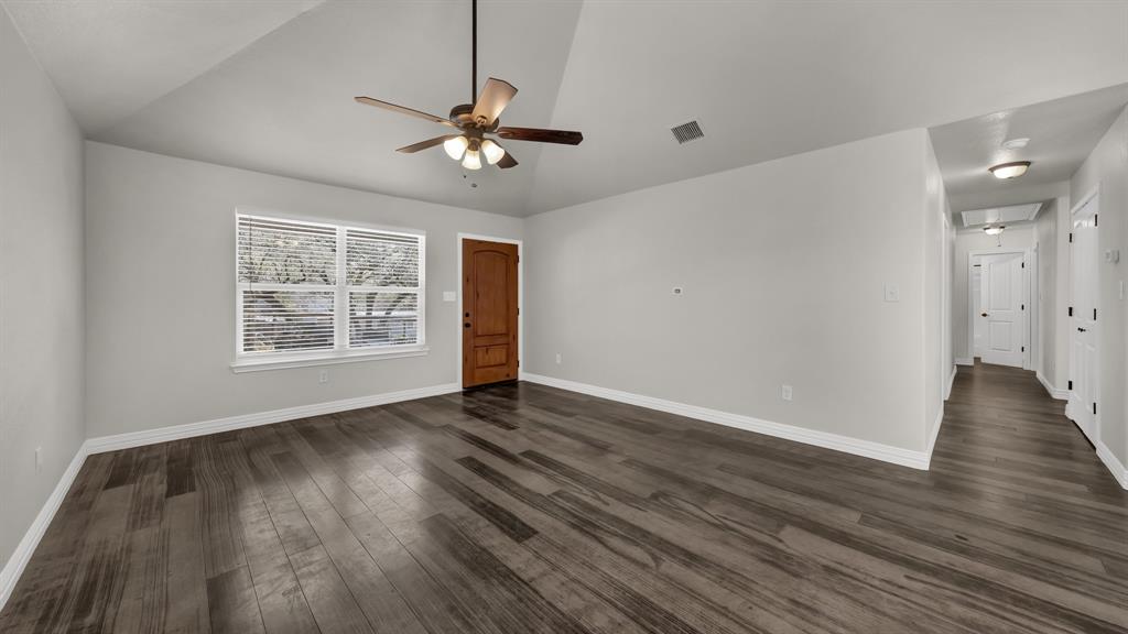 1830 Hitching Post Road Granbury, TX 76049 - Photo 6 of 34 a view of an empty room with wooden floor and a window