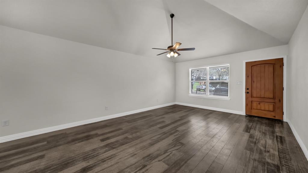 1830 Hitching Post Road Granbury, TX 76049 - Photo 8 of 34 an empty room with wooden floor chandelier and windows