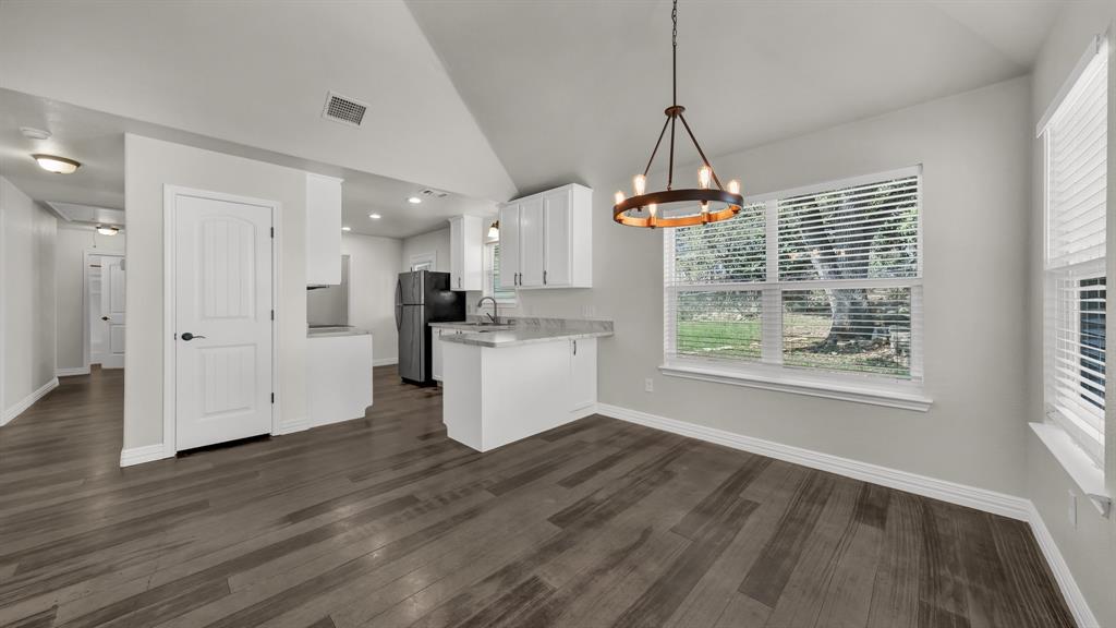 1830 Hitching Post Road Granbury, TX 76049 - Photo 10 of 34 a view of a kitchen with wooden floor and a window
