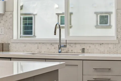 a view of kitchen island a sink wooden floor and a living room
