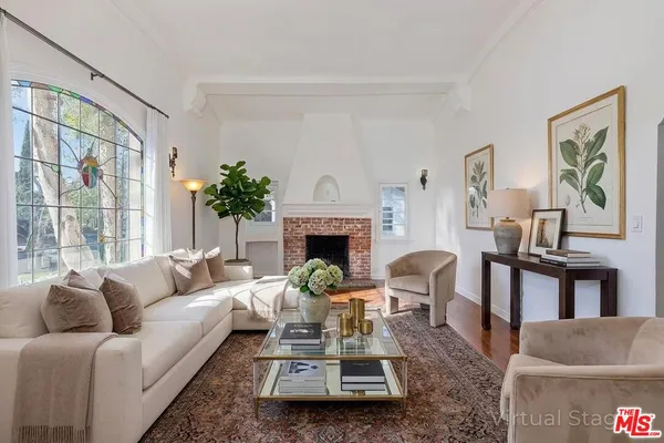 a living room with furniture a fireplace and a large window