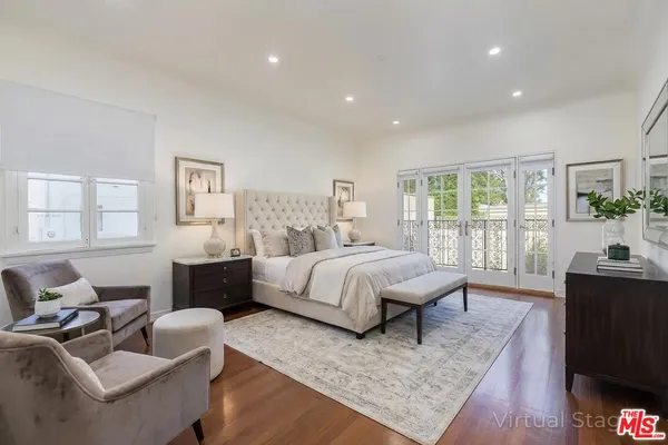 a spacious bedroom with a bed a couch and dresser