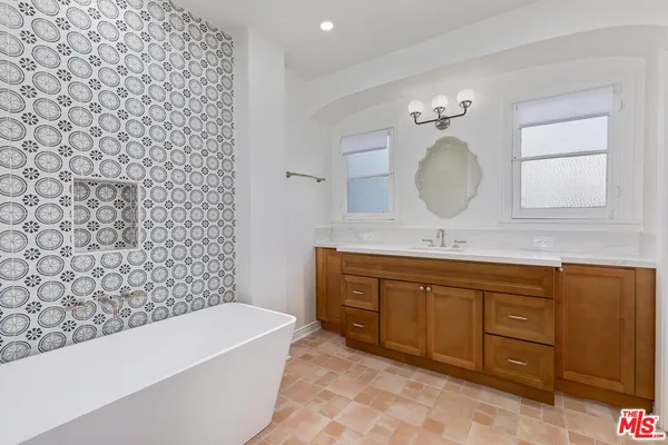a bathroom with a bathtub sink mirror and a toilet
