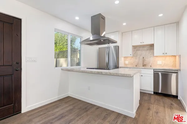 a kitchen with stainless steel appliances granite countertop a sink a stove and a refrigerator