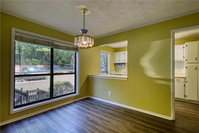 a view of an empty room with glass door and wooden floor