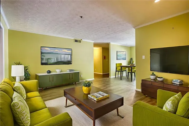 a view of an empty room with wooden floor and a fireplace