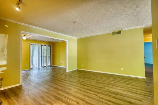 a view of a hallway with wooden floor and a bathroom