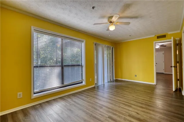 a view of an empty room with wooden floor
