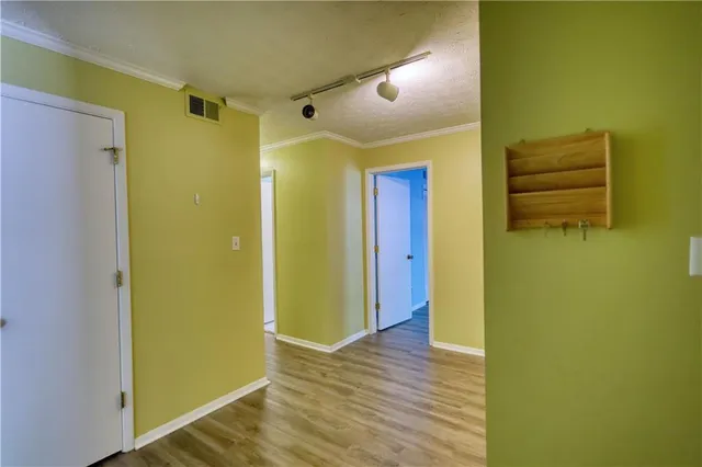 a view of an empty room with a window and wooden floor