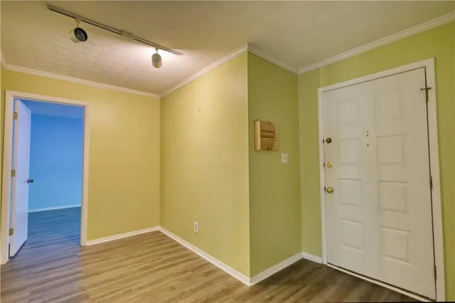 a view of an empty room with window and wooden floor