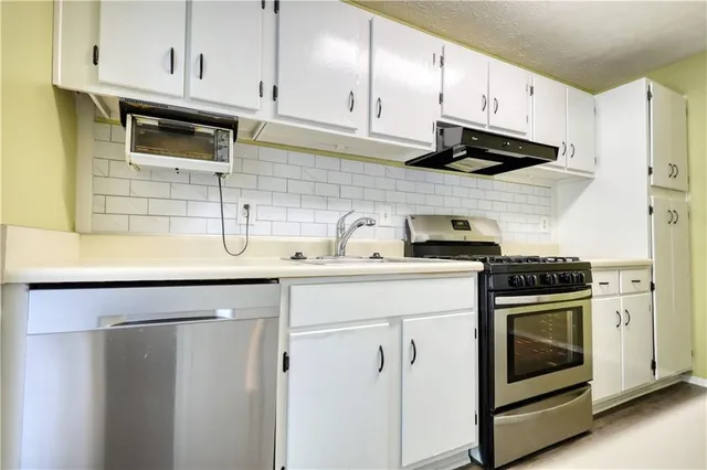 a kitchen with a refrigerator a stove top oven and a sink