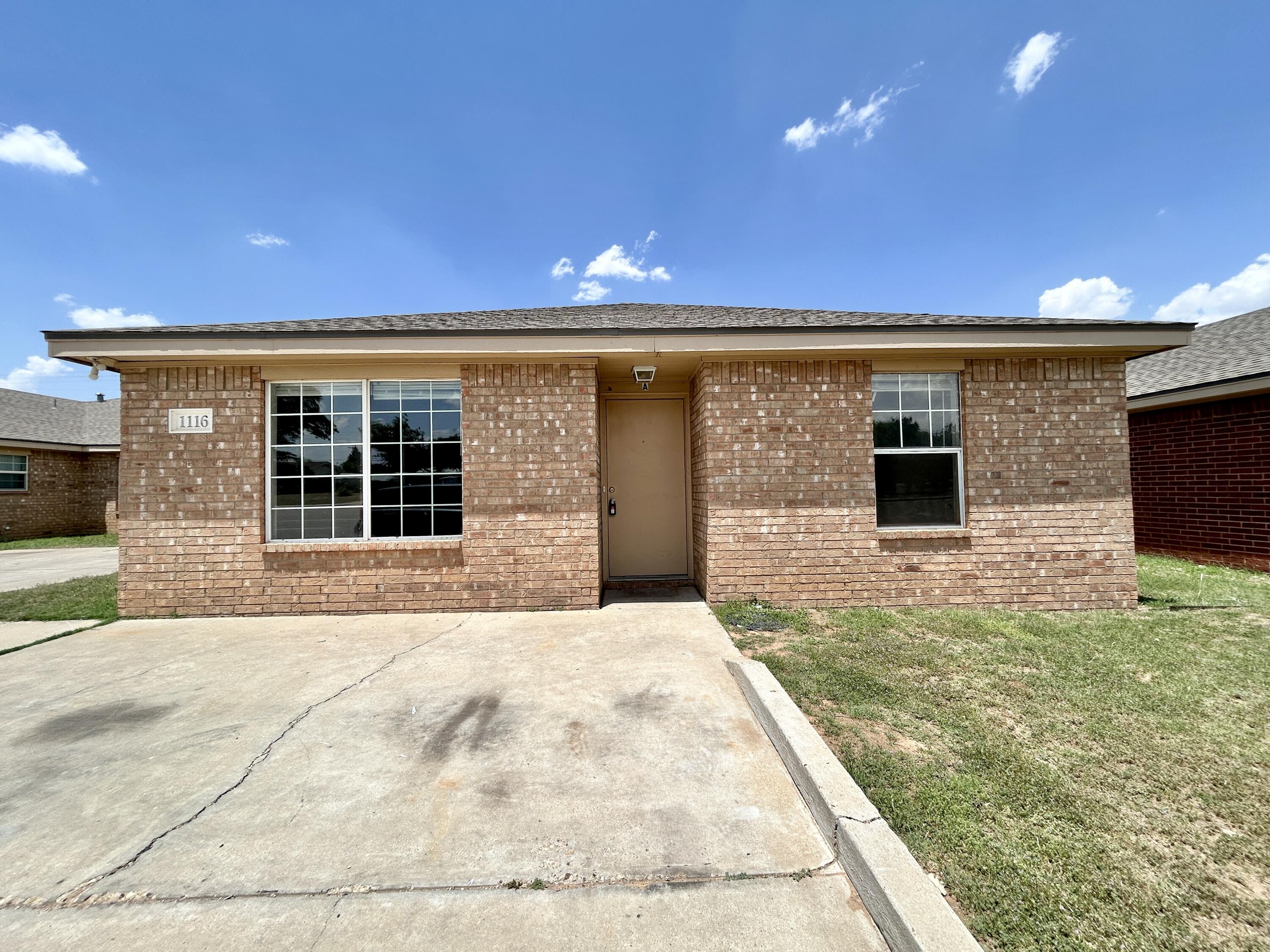 1118 82nd Street, Unit A Lubbock, TX 79423 - Photo 1 of 1 a front view of a house with a yard