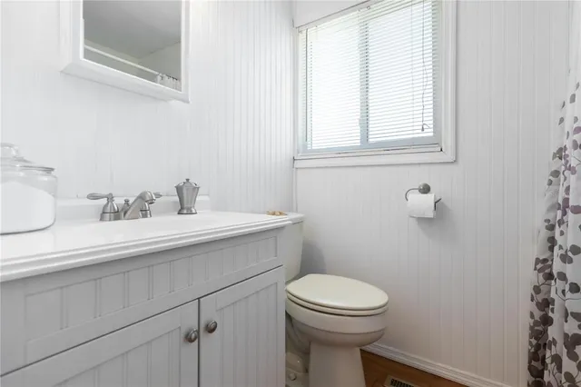 a bathroom with a sink a toilet and a window