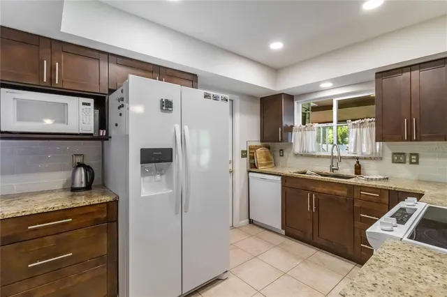 a kitchen with a sink a refrigerator and cabinets