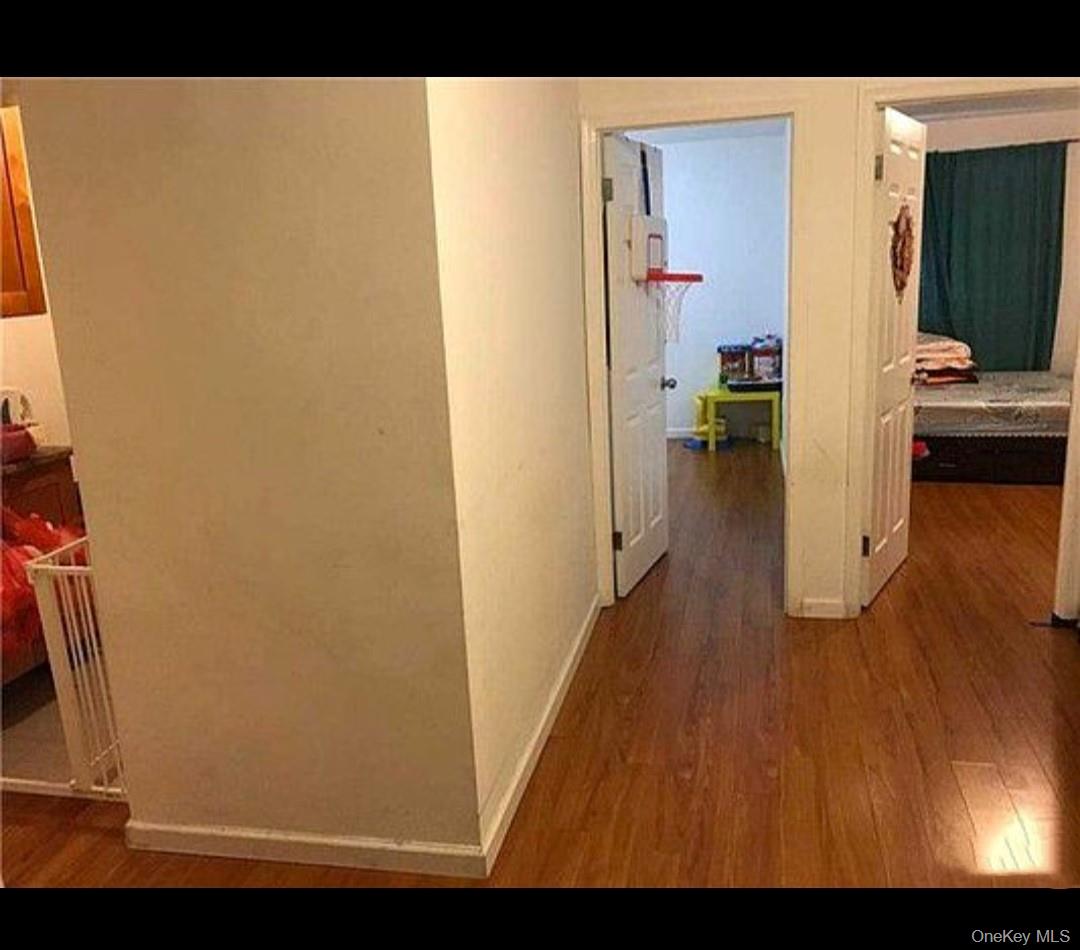 132-35 Sanford Avenue, Unit LD Queens, NY 11355 - Photo 2 of 9 Hallway featuring dark wood finished floors and baseboards