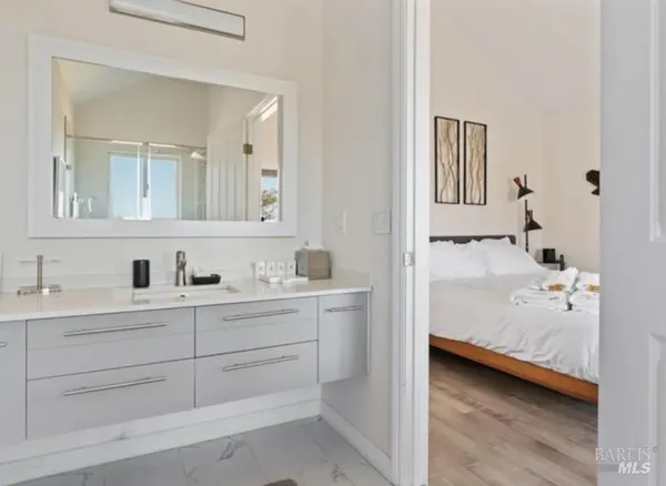 a en suite bathroom with a double vanity sink a mirror and a bathtub