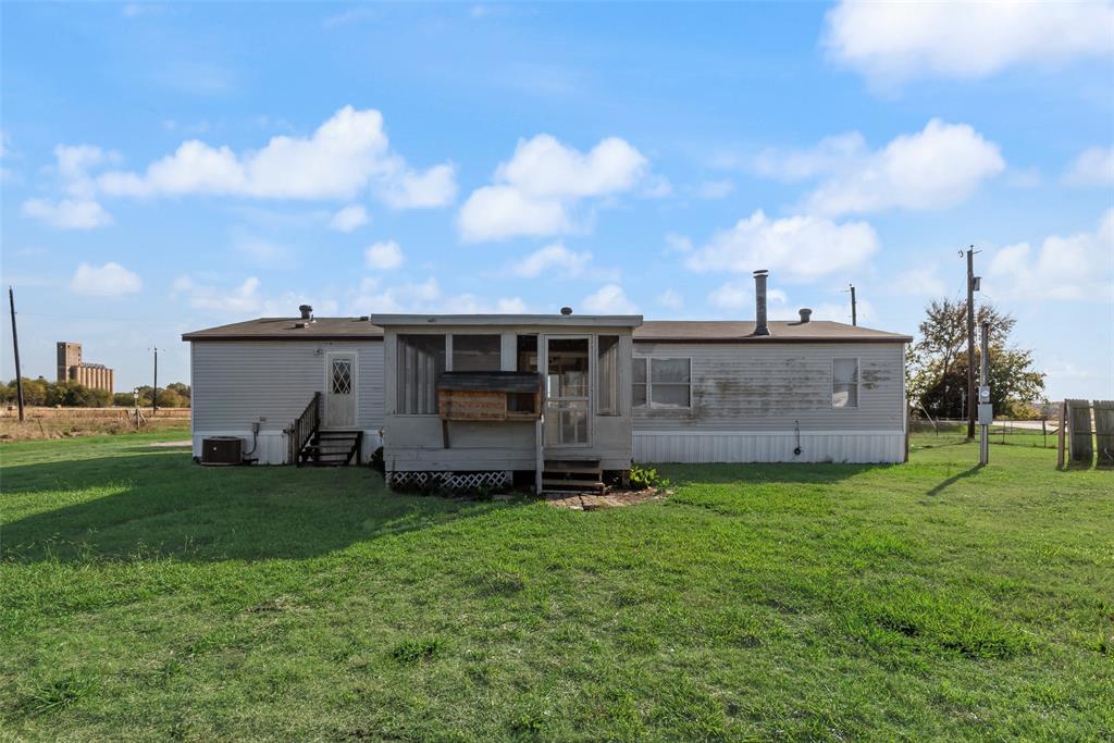 817 Kaufman Street Rosser, TX 75158 - Photo 26 of 29 Rear view of house featuring a sunroom, a lawn, and entry steps