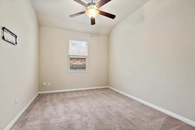 an empty room with a window and a fan