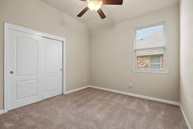 an empty room with a chandelier fan