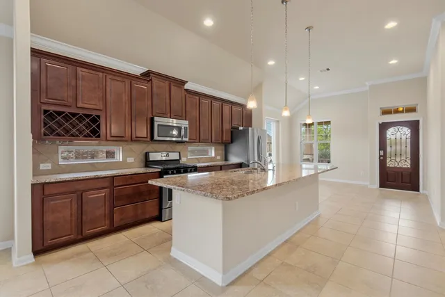 a large kitchen with stainless steel appliances granite countertop a stove and cabinets