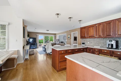 a kitchen with a stove sink cabinets and wooden floor