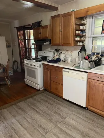 a kitchen with granite countertop a sink cabinets stainless steel appliances and a window