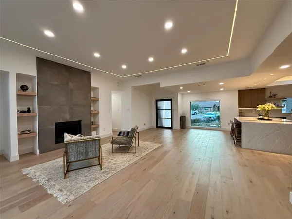 a large kitchen with stainless steel appliances a stove a sink and a refrigerator