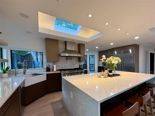 a kitchen with kitchen island a counter top space cabinets and stainless steel appliances