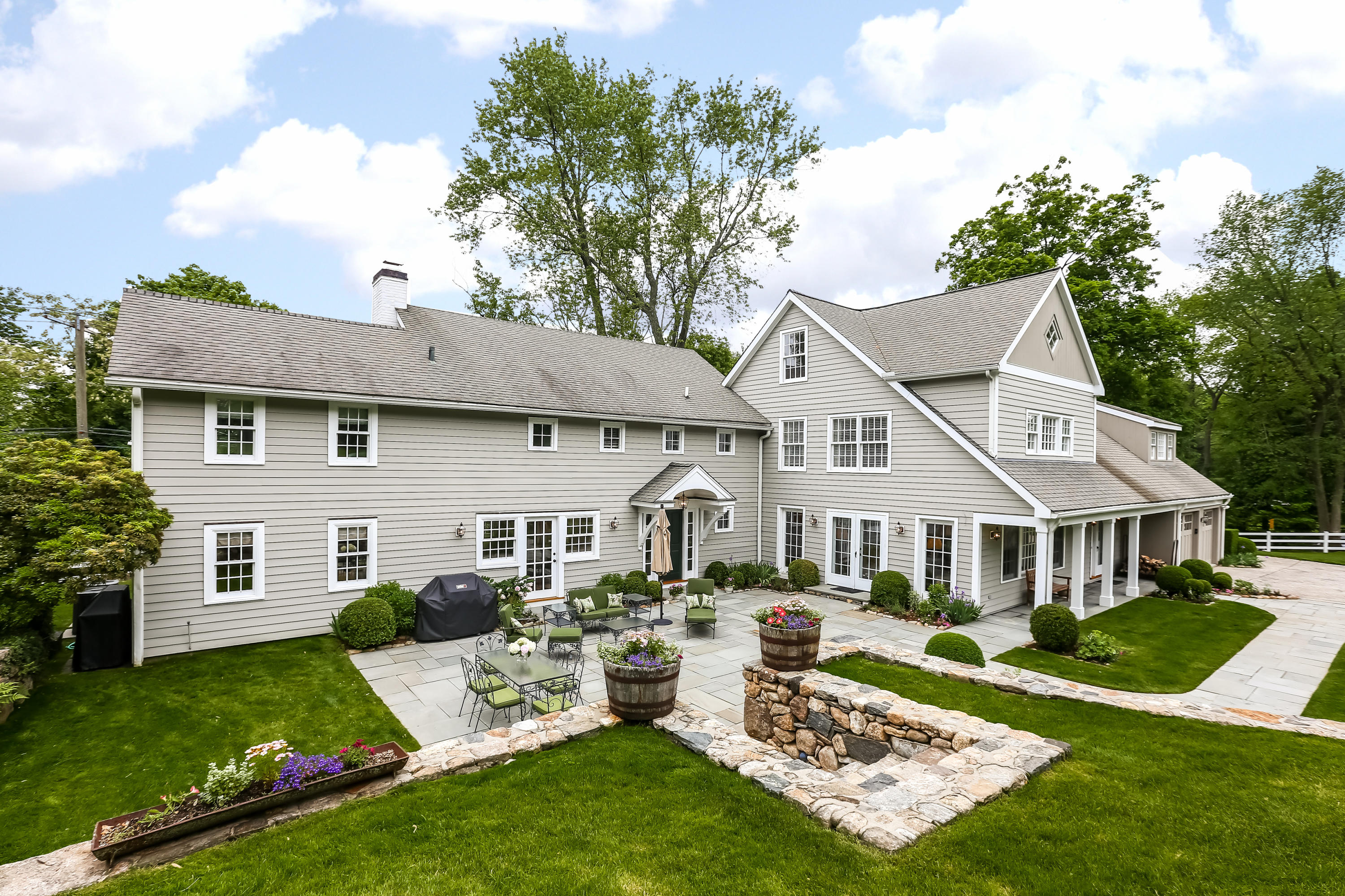 2 Saddle Ridge Road Darien, CT 06820 - Photo 3 of 33 a front view of a house with a yard table and chairs