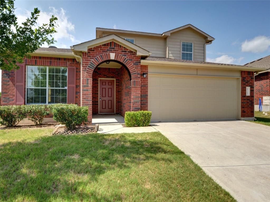 a front view of a house with a yard and garage