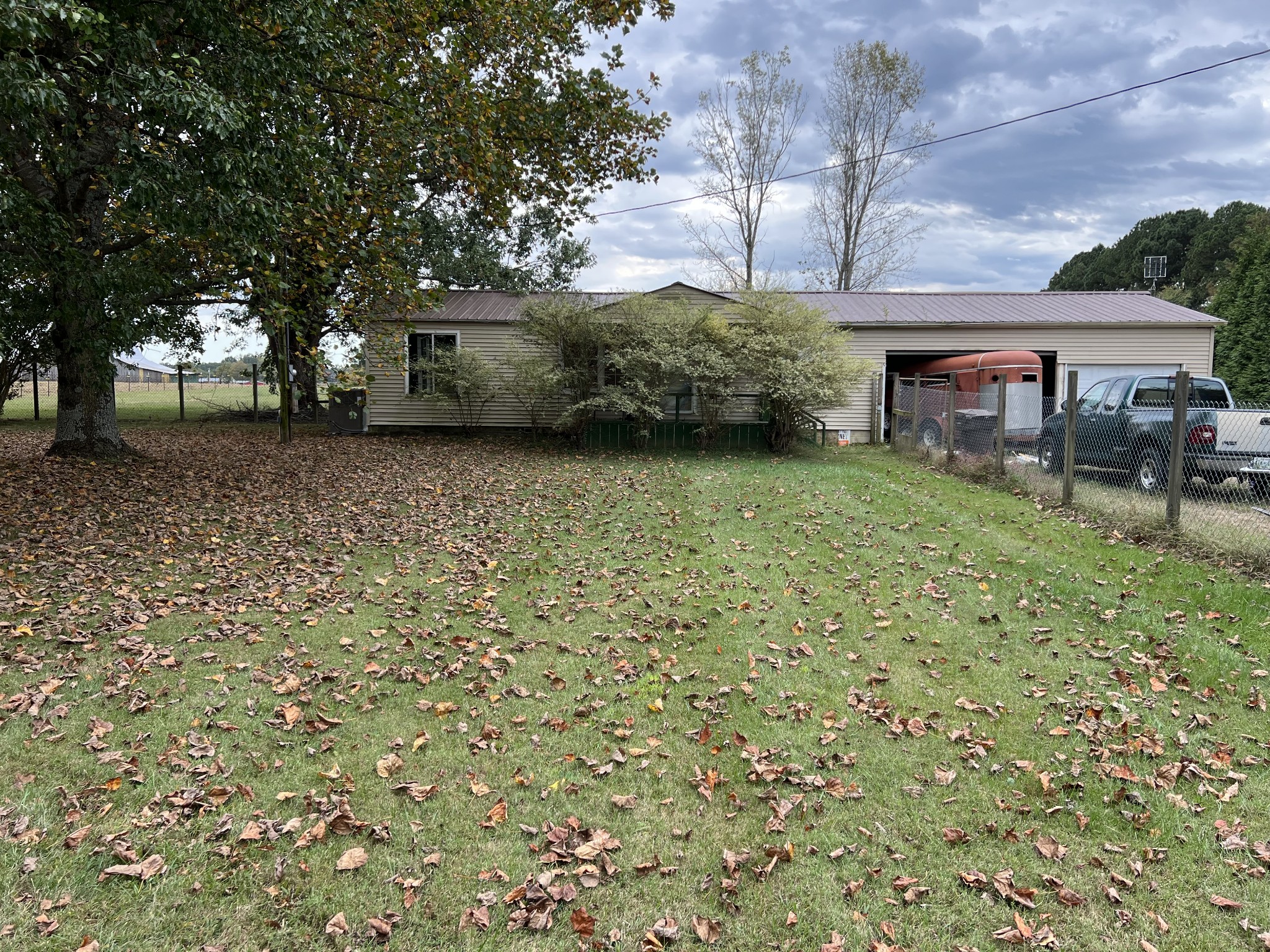 3554 Asbury Road Manchester, TN 37355 - Photo 1 of 23 a backyard of a house with table and chairs under an umbrella