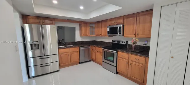 a kitchen with stainless steel appliances granite countertop a refrigerator stove top oven and sink