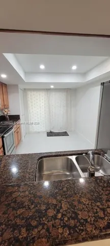a view of a kitchen with a sink and a stove top oven