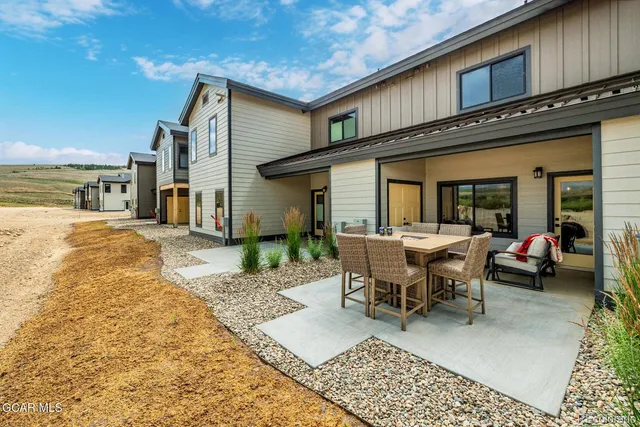 a view of a house with backyard and sitting area