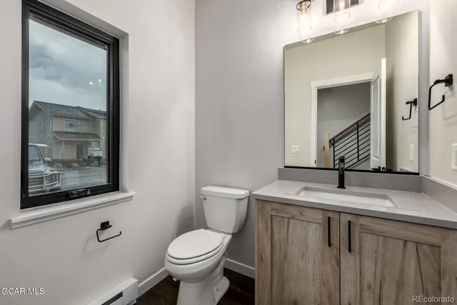 a bathroom with a toilet sink and mirror