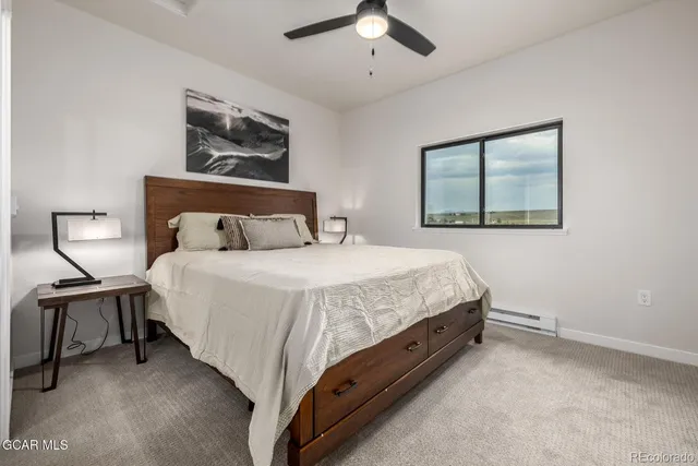 a bedroom with a bed and painting on the wall